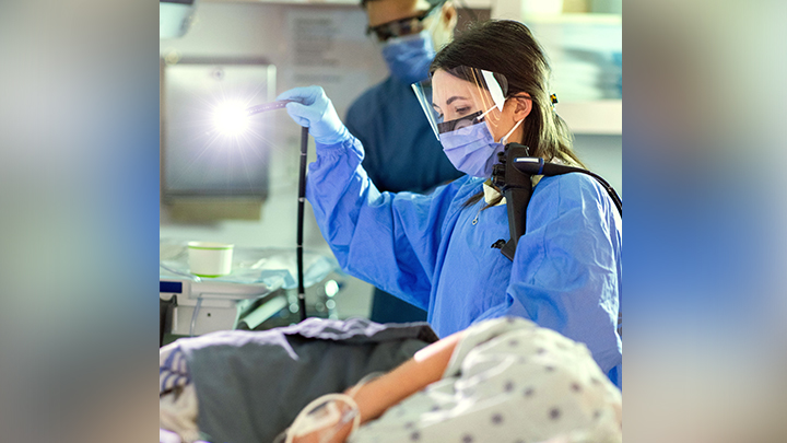 Dr. Felske preps the endoscopic camera before she begins a colonoscopy procedure under the guidance of Dr. Mandeep Sandhu.