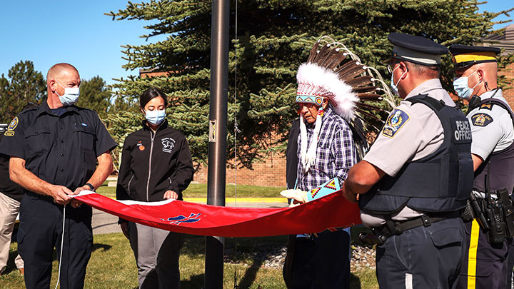 Siksika Nation elder Clement Leather says a prayer over the Siksika Nation flag before it is raised at Strathmore District Health Services.