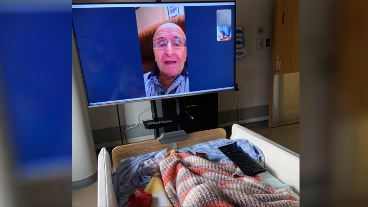 Paul Routhier, 92, enjoys a virtual visit with his wife, Lorraine (not shown), a continuing care resident at the St. Therese - St. Paul Healthcare Centre, thanks to a new 55-inch smart TV donated by Family and Community Support Services.