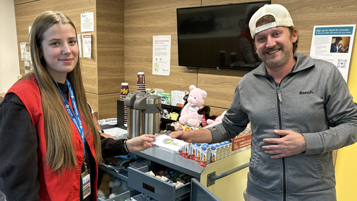 Sydney Janzen shares a Sunshine Card with Aaron Dragland, a new dad who stopped by the comfort cart in the Neonatal Intensive Care Unit to pick up a treat for babe and mom.