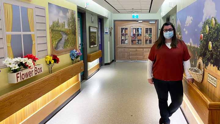 AHS recreation therapist Nicole Kulba poses in the newly installed Edith Crosland Memorial Gardens hallway in the Tofield Health Centre’s continuing care unit for residents with dementia. The new murals help create a comfortable, homelike environment for residents.