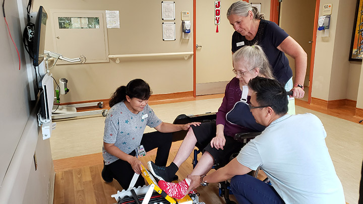 Recovering stroke patient Val Lewis is assisted with her exercises by physiotherapist Leah Sistoso, at front, occupational therapy assistant Diones Tizon and therapy assistant Diane Mills.