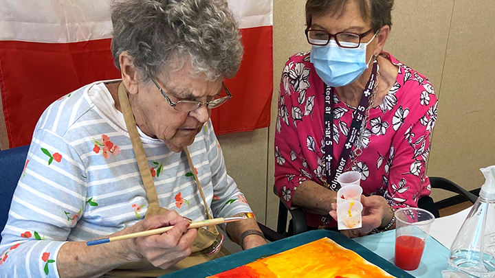 Vivian, left, works her creative magic on a piece of art, which she later entitled: You Better Start Running. Her newfound friend and fellow participant Rosalie watches on during the Opening Minds through Art session at the Drumheller Health Centre.