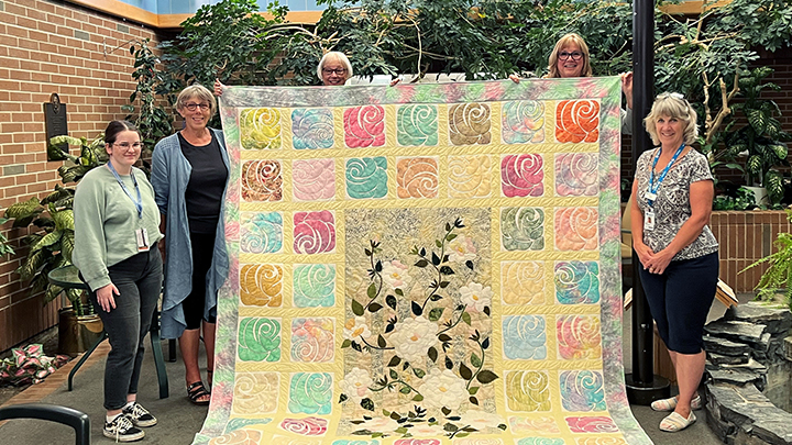 Volunteers gave their time and talents to lovingly handcraft this gorgeous quilt to support the delivery of the White Rose program within Stettler Hospital and Care Centre. This quilt will provide gentle acknowledgement when a patient or resident passes away, as well as increase facility awareness and foster a sympathetic, quiet and compassionate atmosphere for patients and their loved ones. Pictured, from left, are: Jessie Brinson, a recreation assistant; volunteers Leona Thorogood, Karin Phibbs and Wendy Rowledge; and Sheila Gongaware, volunteer coordinator.